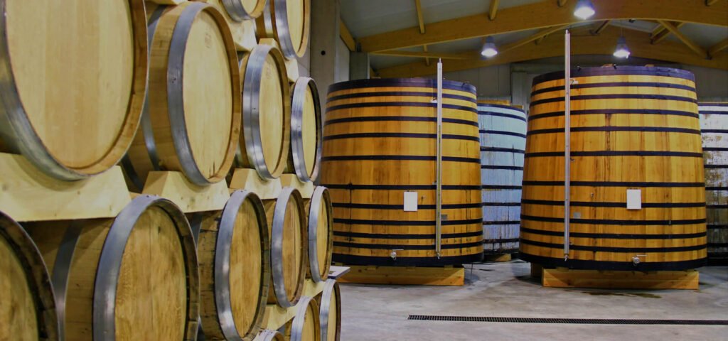 Chai de vieillissement des Vignerons d’Oléron : fûts de chêne et grands foudres pour le cognac et le pineau