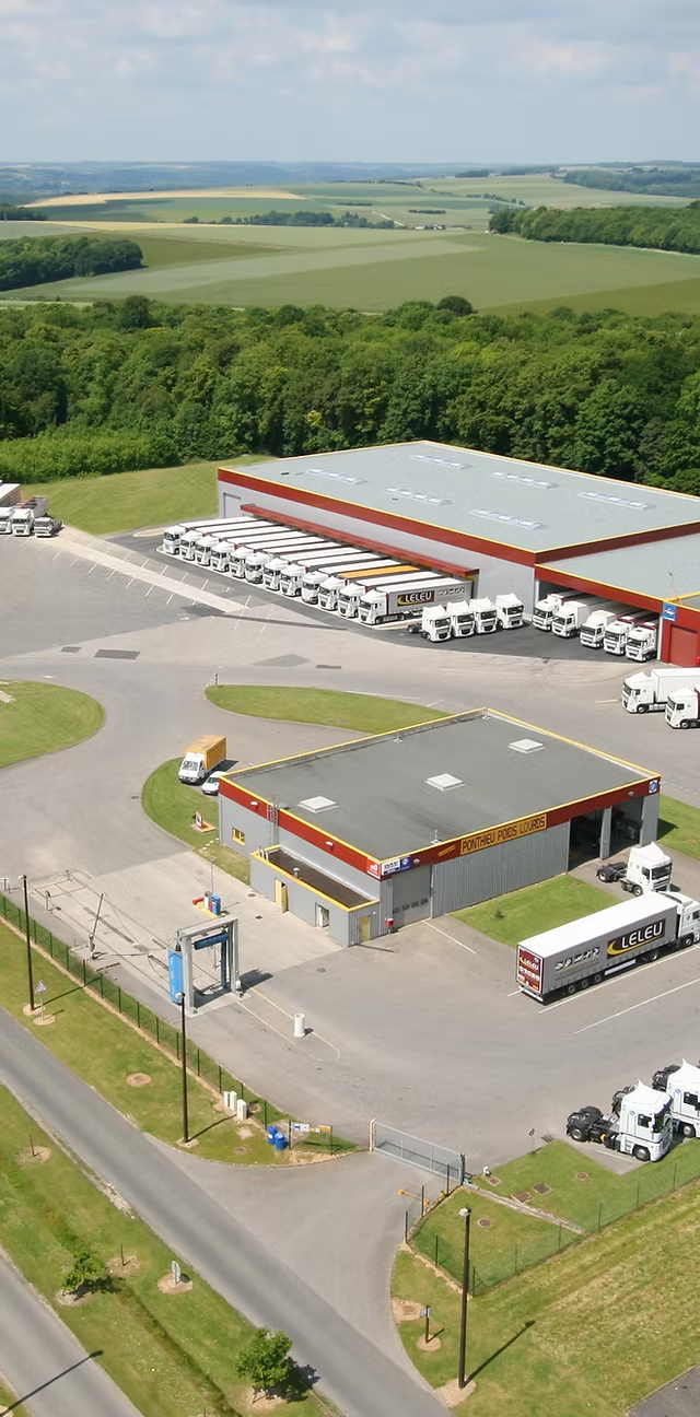 Vue aérienne du site Leleu de Flixecourt : entrepôts et semi-remorques du groupe de transport et logistique